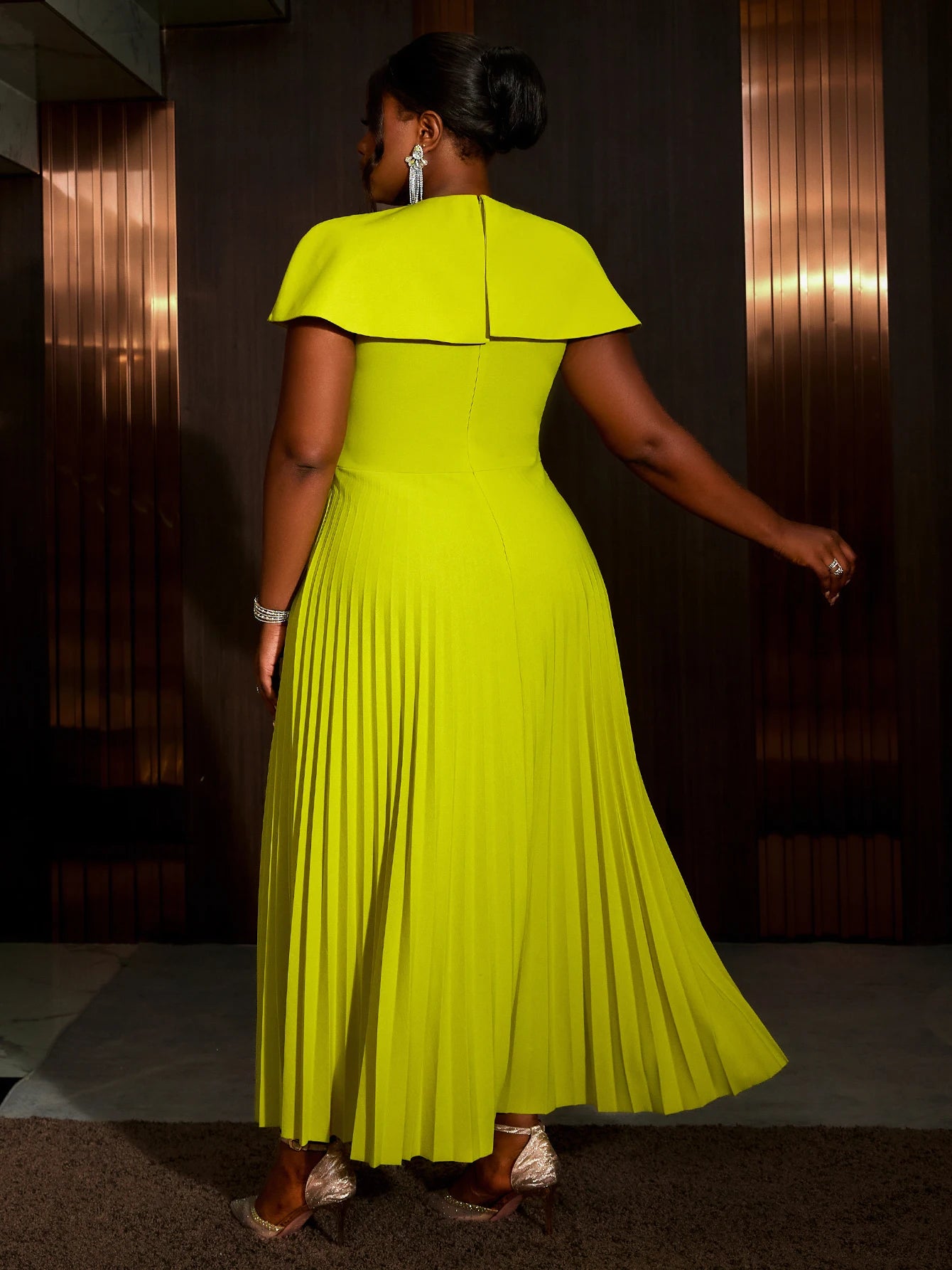 This A-Line career dress features a round collar, cape sleeves, and an asymmetric pleated design